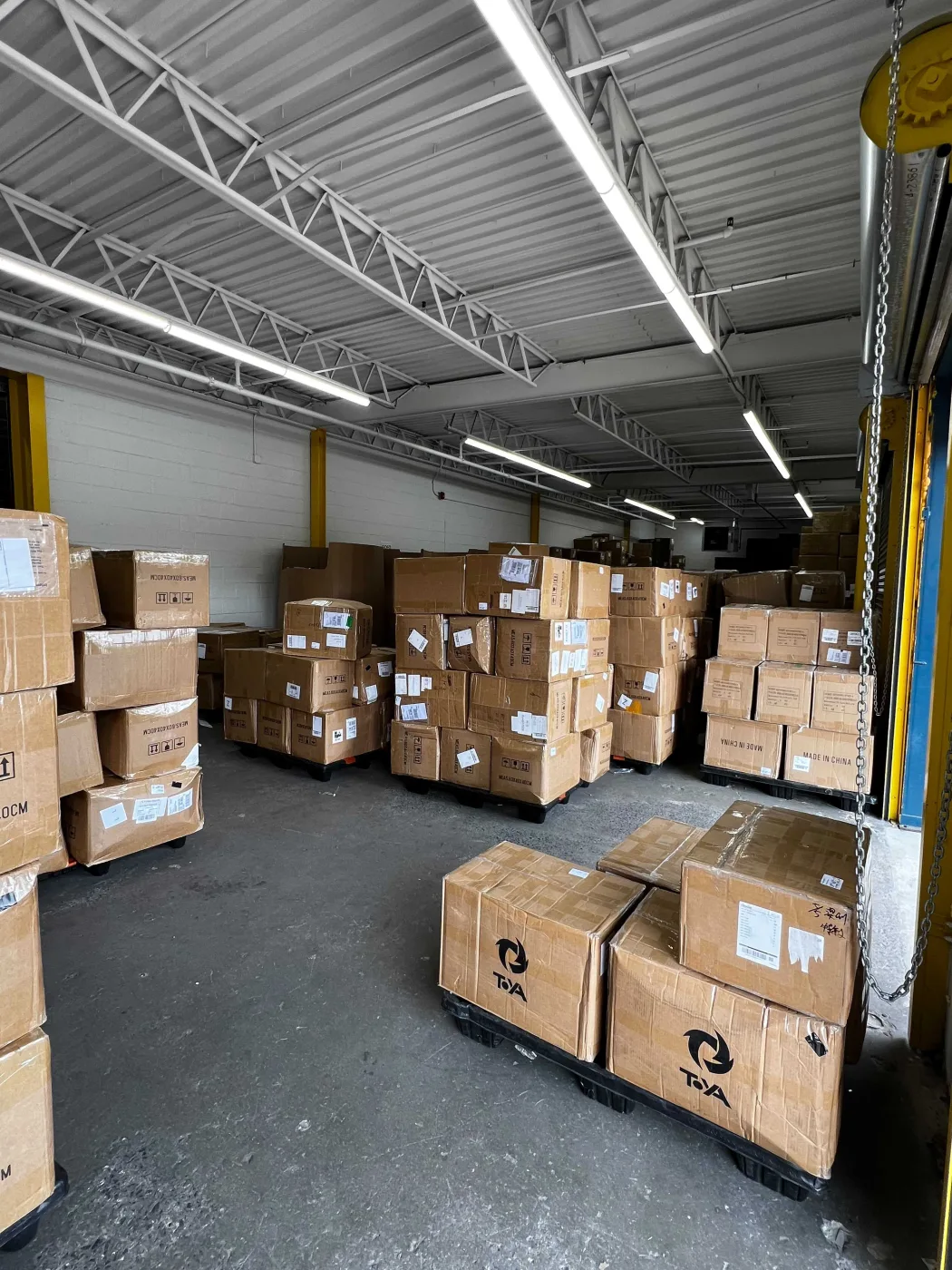 Palletised inbound cartons staged beside the roller door at the New Jersey warehouse