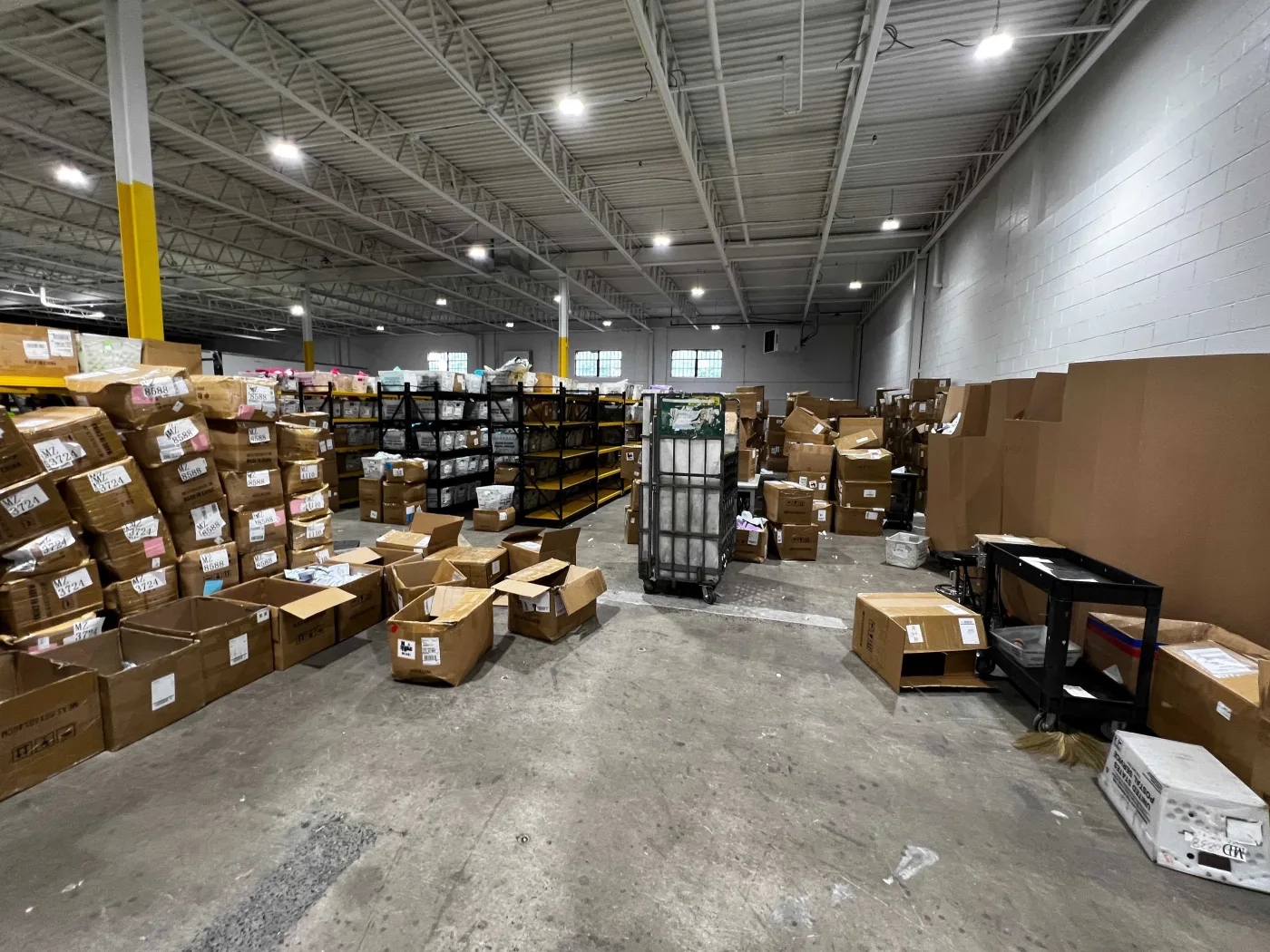 Wide view across the operations floor with SKU-labelled cartons and pick shelving