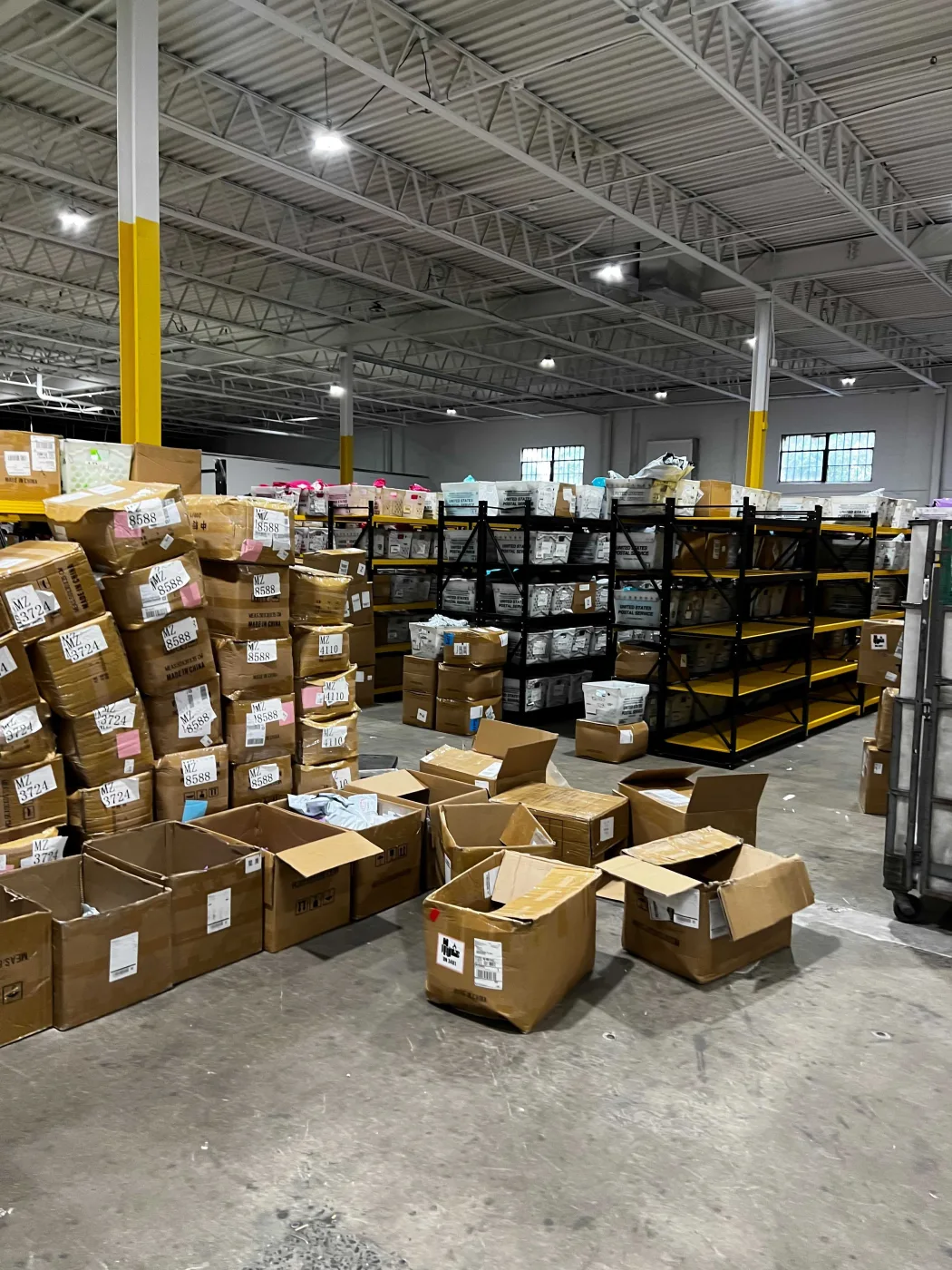Pick shelving holding labelled bins and small-parcel stock