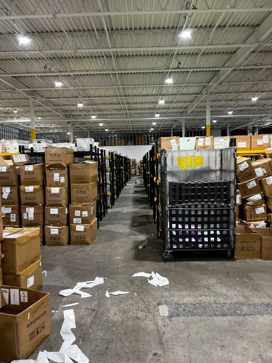 Long aisle of racked storage running the depth of the warehouse